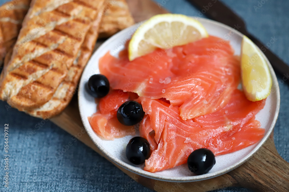 Salted salmon fillet with lemon and olives.