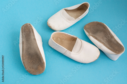 children's white dancing shoes on a blue background. Children's Ballet