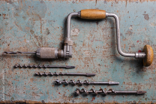 Rotterdam, Netherlands - 11-11-2022: Vintage brace or hand drill with extra drills flat lay