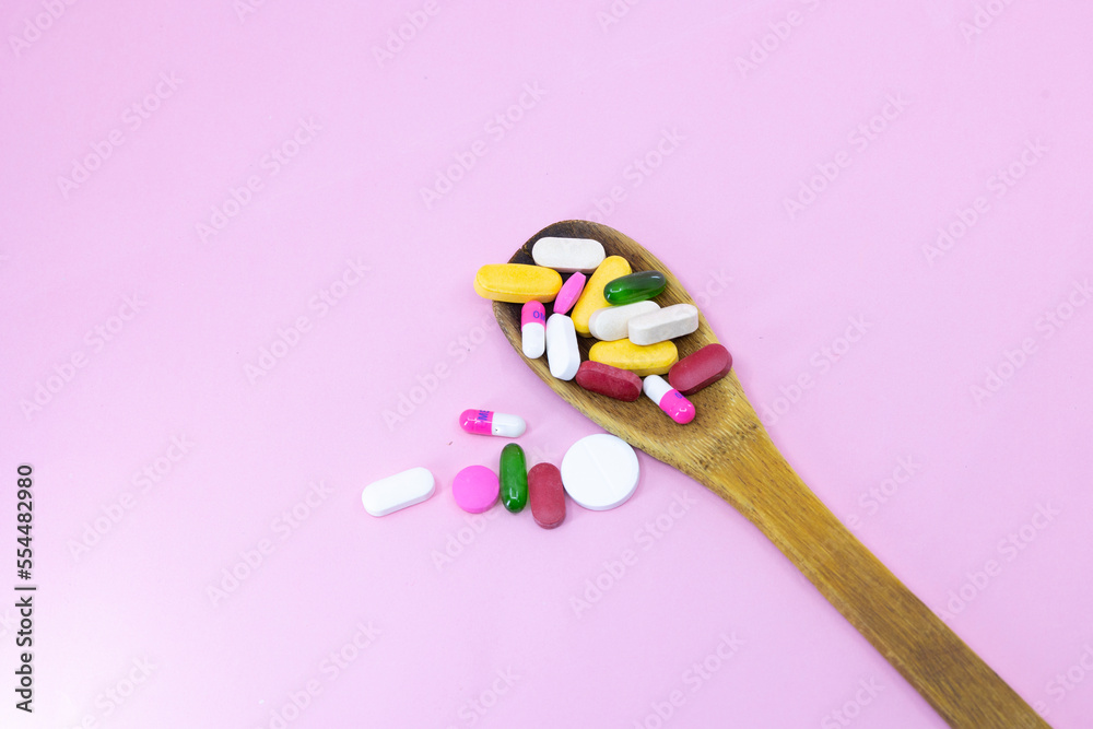 Mixed medicine pills, tablets on wooden spoon on blue background. Many different pills with space for text. Health care. Top view. Copy space. New image. Pharmaceutical picture. and selective Mixed medicine pills, tablets on wooden spoon on blue background. Many different pills with space for text. Health care. Top view. Copy space. New image. Pharmaceutical picture. and selective