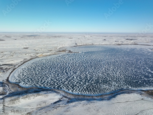 Lake Maibalyk covered with ice in Burabai National Park. Cold wintry day. Aerial top view. photo