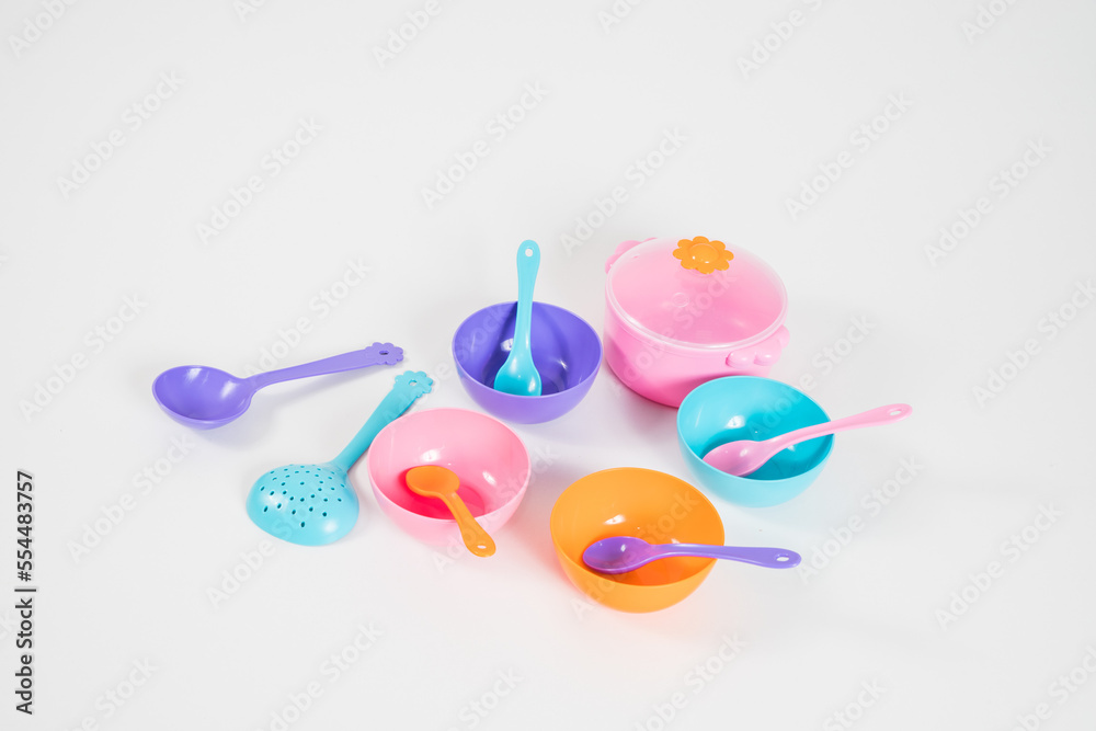 A set of multi-colored children's plastic utensils for games on a white background. A set of multi-colored children's plastic utensils for games on a white background.