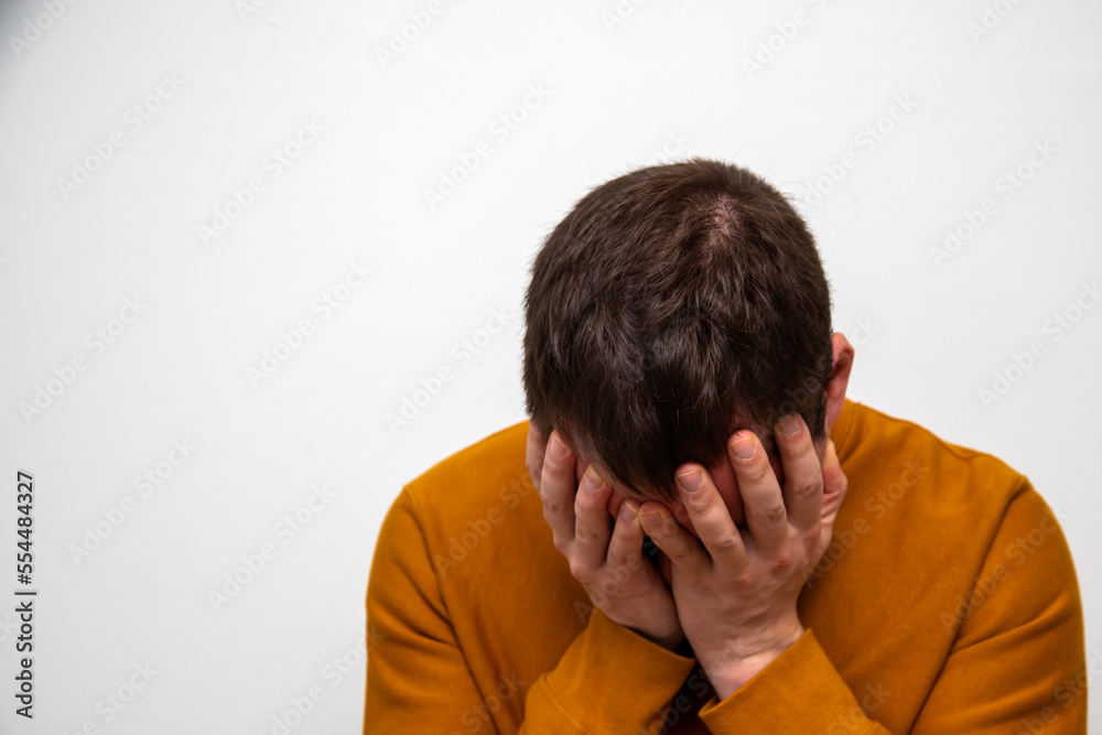 Man covering his face with his hands out of sadness Man covering his face with his hands out of sadness