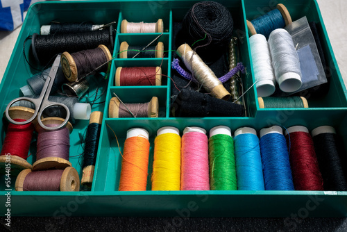 Vintage sewing kit. A set of multi-colored spools of thread. A set of multi-colored threads, needles and scissors