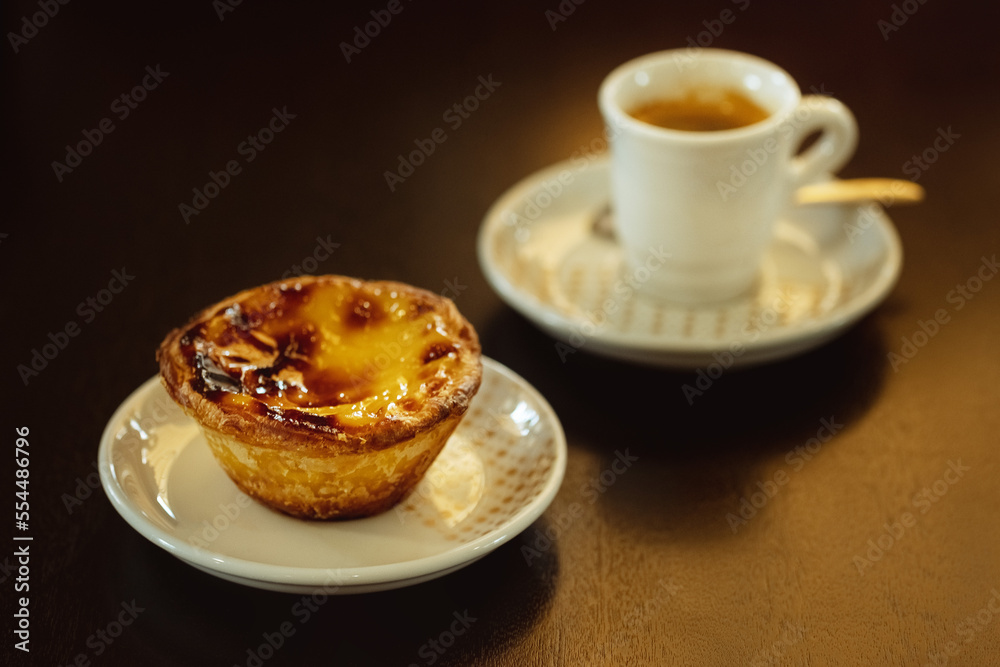 Portuguese summer breakfast. Pastel de nata and small coffee. Sweet egg custard tart pastry on black table. Portuguese summer breakfast. Pastel de nata and small coffee. Sweet egg custard tart pastry on black table.