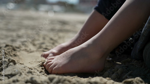 Child foot on sand outside. Closeup kid barefoot feet at beach feeling nature