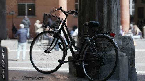 Bicycle leaning on old European column. Bike parked outside. Urban alternative transportation