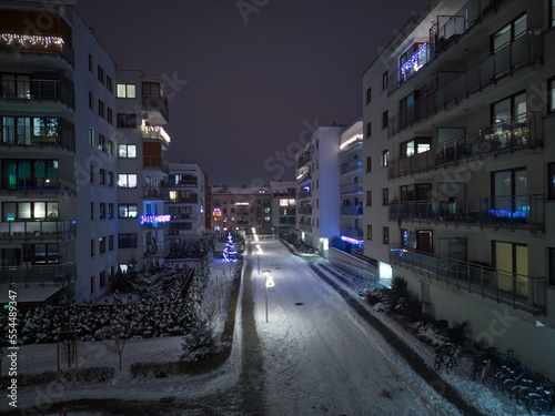 Aerial view of modern housing estate in winter. Christmas lights on glass balconies. Winter scenery. Outdoor Christmas Apartment Decor.