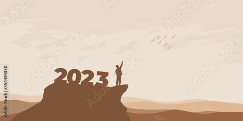 New Year 2023 concept. Man meets dawn in mountains for new year 2023. New Start motivation inspirational quote message on silhouette man