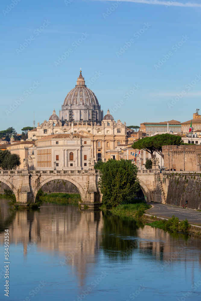 Rome, Italy - October 9, 2020: Aelian Bridge (Ponte Sant'Angelo) across the the river Tiber, completed in 2nd century by Roman Emperor Hadrian. In the background, the dome of the Vatican Basilica