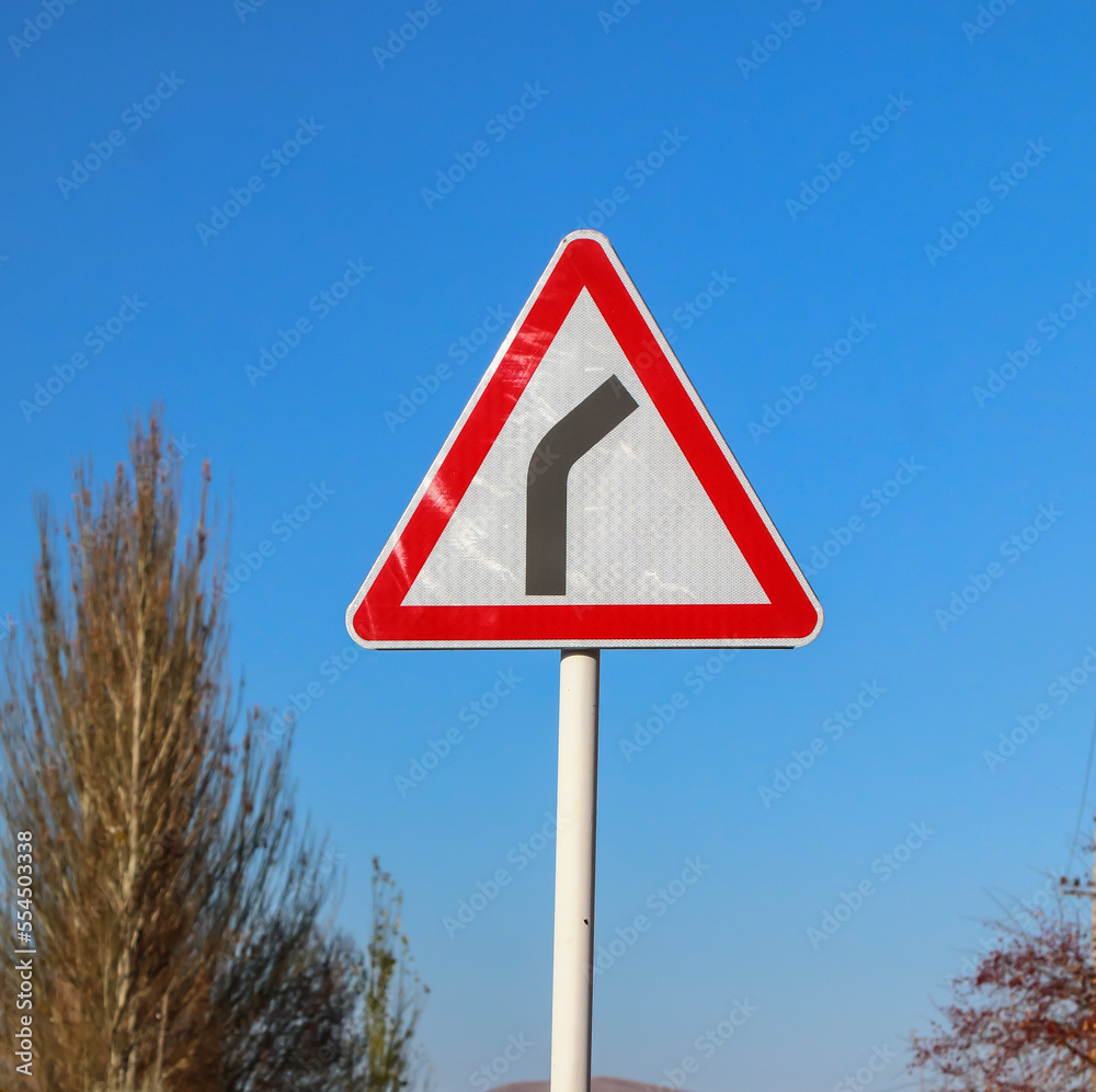 Road sign on a road in a mountainous area against the sky