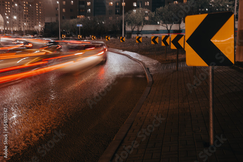Evening car traffic in a big city. Cars in motion and standing in traffic jams. Long exposure exposure and headlight trails