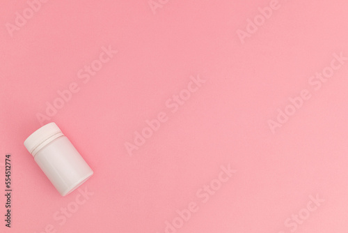 Medicine with pills on pink background