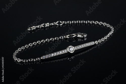 silver bracelet with diamonds on black background.