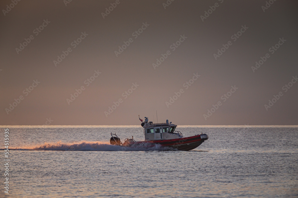 coast guard boat at sea at sunset view from the shore
