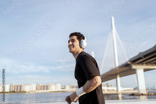 A man is an active runner with headphones, an athlete uses fitness clothes, running training