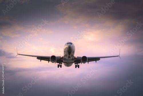 passenger plane landing at sunset