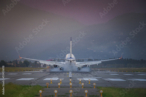 passenger plane landing at sunset in the mountains