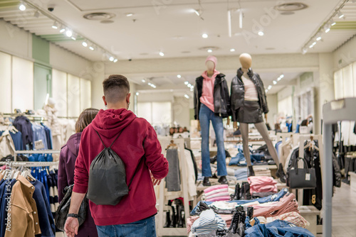 Billede på lærred Couple Entering Through the Door of a Women's Clothing Store to Do Their Shoppin