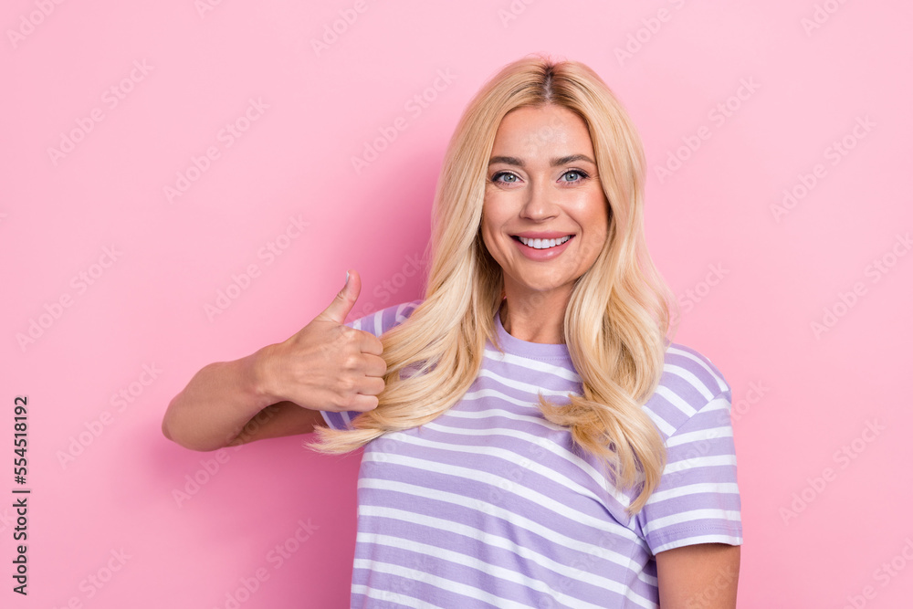 Photo of young successful positive smiling blonde hair toothy beaming smile thumb up like recommend new brand isolated on pink color background Photo of young successful positive smiling blonde hair toothy beaming smile thumb up like recommend new brand isolated on pink color background