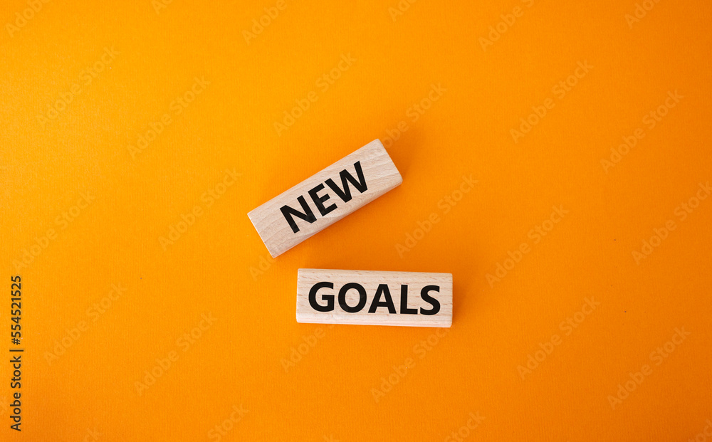 New goals symbol. Wooden blocks with words New goals. Beautiful orange background. Business and New goals concept. Copy space. New goals symbol. Wooden blocks with words New goals. Beautiful orange background. Business and New goals concept. Copy space.