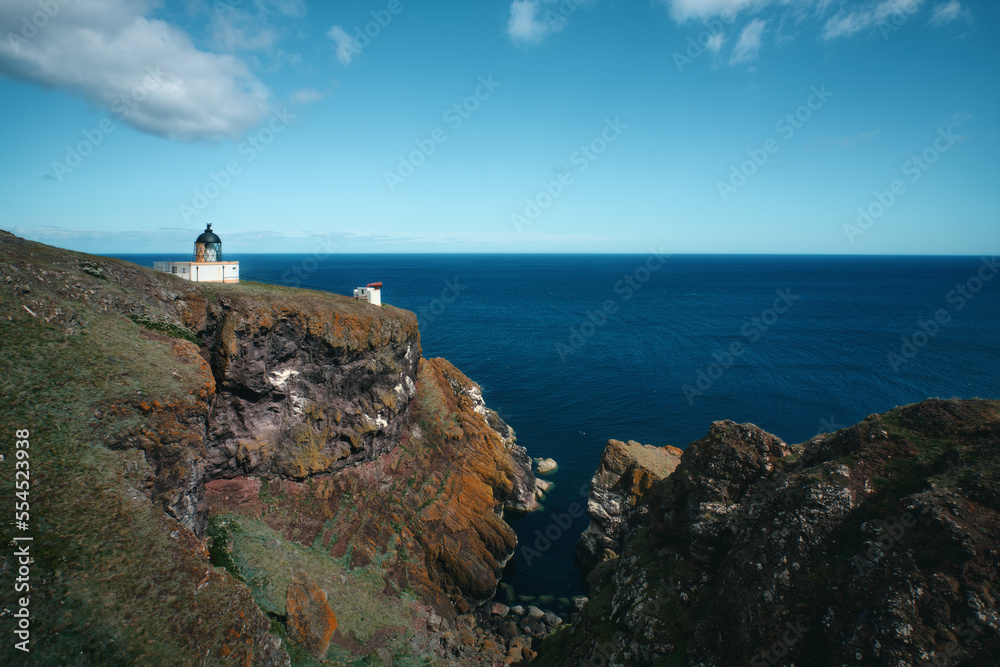 The Scottish seashore and the lighthouse on the cliff. St Abb's Head National Nature Reserve on the Berwickshire coastline, Scotland, UK