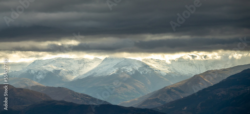 Stormy clouds with sunbeams over snowy mountains in Granada (Spain)