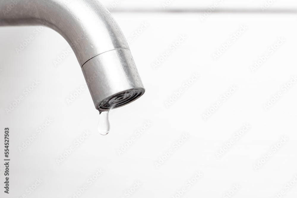 Water dripping from the faucet in the bathroom. Water faucet close-up. Saving water Water dripping from the faucet in the bathroom. Water faucet close-up. Saving water