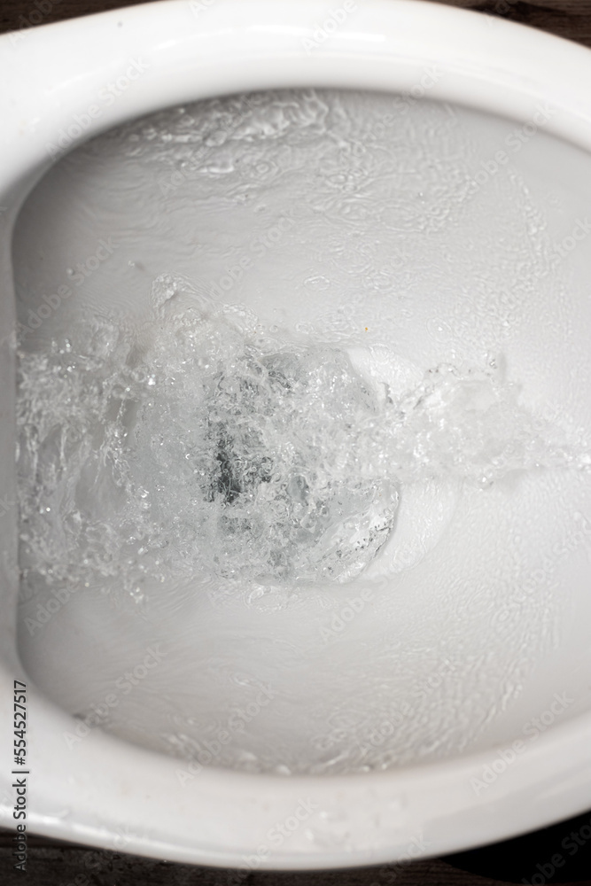 Toilet while flushing urine with water. A stream of water in the toilet bowl Toilet while flushing urine with water. A stream of water in the toilet bowl
