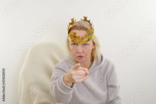 Middle age caucasian woman wearing queen crown angry and mad raising fist frustrated and furious while shouting with anger. rage and aggressive concept wearing princess crown angry 