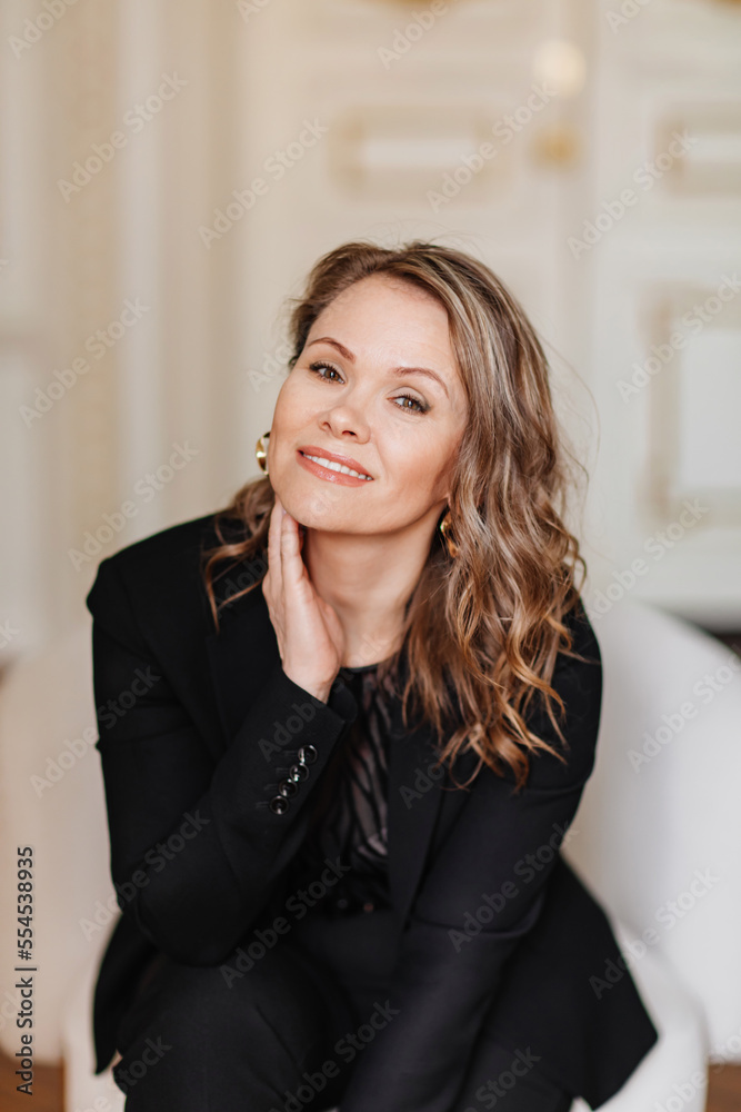 an attractive, feminine and confident woman in a black suit. an attractive, feminine and confident woman in a black suit.