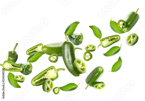Obraz na płótnie Flying green jalapeno peppers and fresh basil leaves on white background