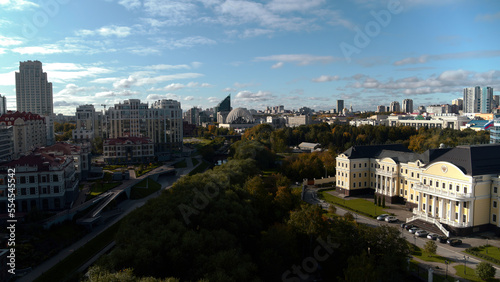 A wonderful bird's-eye view. Stock footage.The landscape on which large high-rise buildings, parks are visible, a river flows in the middle and parks with benches for tourists are made around it.