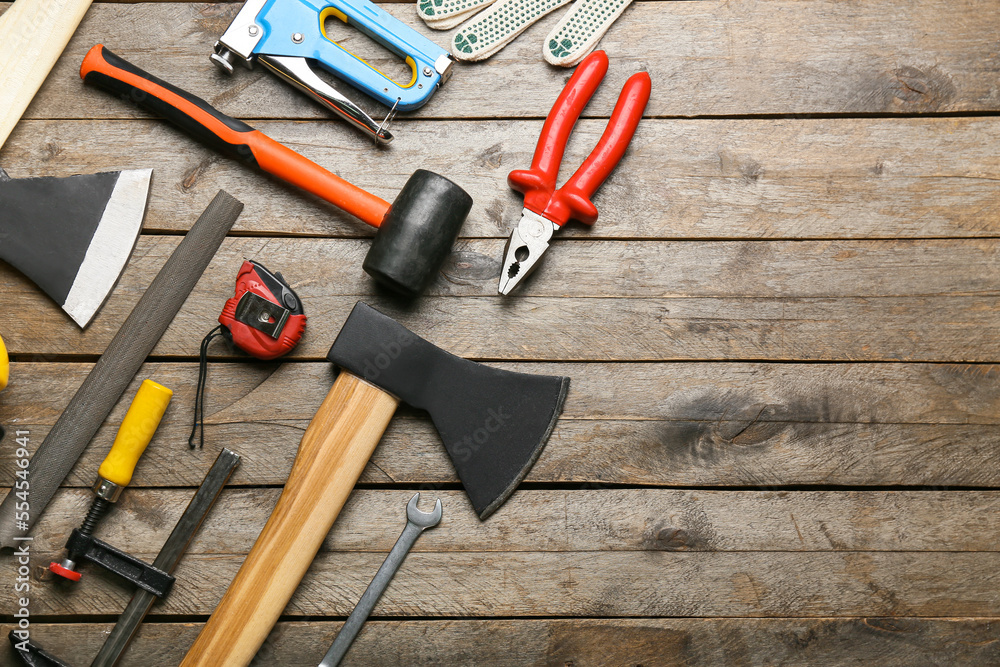 Ax with builder's supplies on wooden background