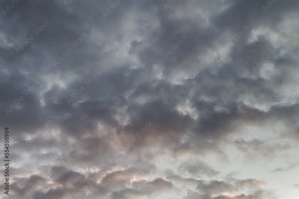 Summer evening sky in the picturesque clouds, lit by the rays of the setting sun.