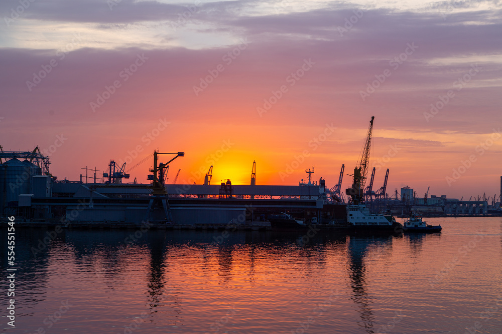 sunset in industrial landscape of commercial seaport. Sunset at seaport.