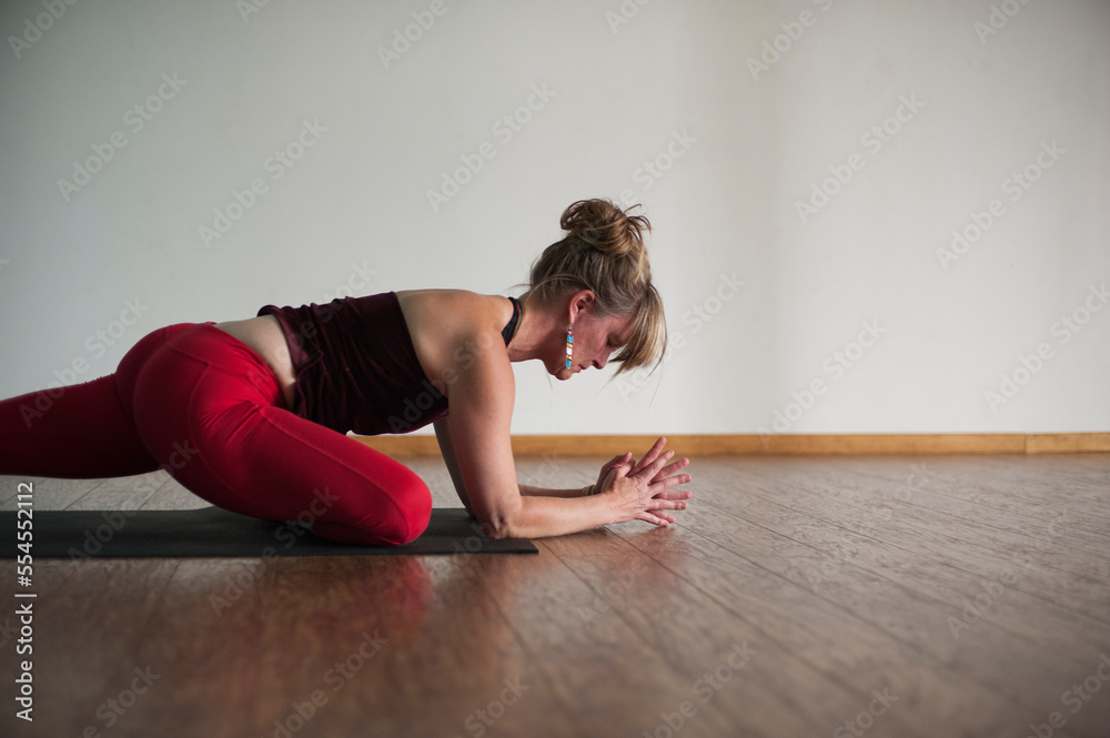 a serious of photographs demonstrating the practice of a yoga teacher wearing red yoga pants in a studio with a wood floor. a serious of photographs demonstrating the practice of a yoga teacher wearing red yoga pants in a studio with a wood floor.