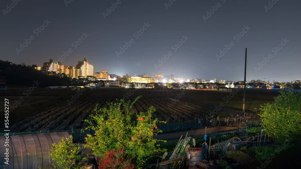 Time Lapse: Cars streak through fields on edge of small town at night Time Lapse: Cars streak through fields on edge of small town at night