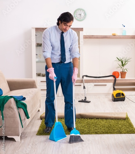 Young businessman cleaning the house