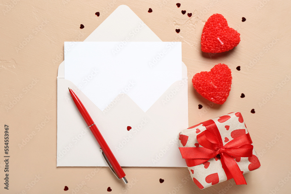 Blank letter with gift, candles and hearts on beige background. Valentine's Day celebration Blank letter with gift, candles and hearts on beige background. Valentine's Day celebration