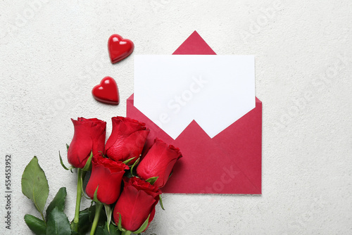 Fototapeta Naklejka Na Ścianę i Meble -  Blank letter with roses and candies on white background. Valentine's Day celebration