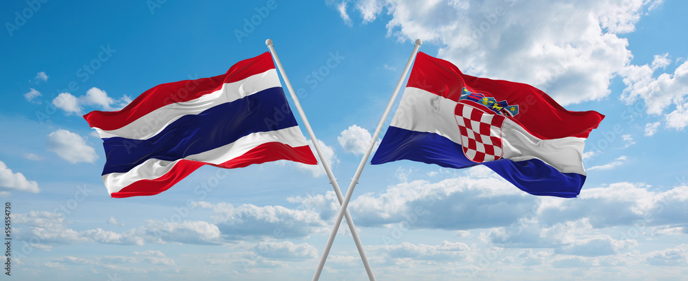 two crossed flags Croatia and Thailand waving in wind at cloudy sky ...