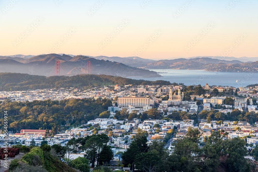 Elevated view of a residential district of San Francisco  at sunset in autumn. The Golden Gate bridge and the bay are in background.