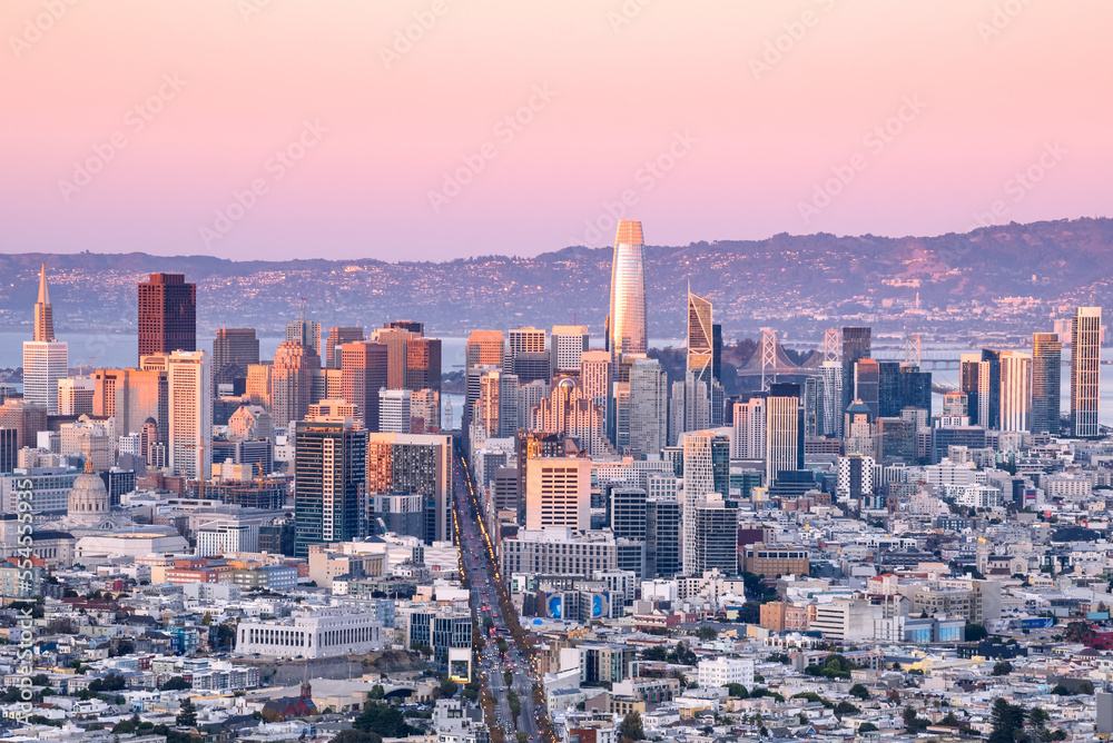 Skyline of San Francisco financial district glowing in pink sunset light in autumn