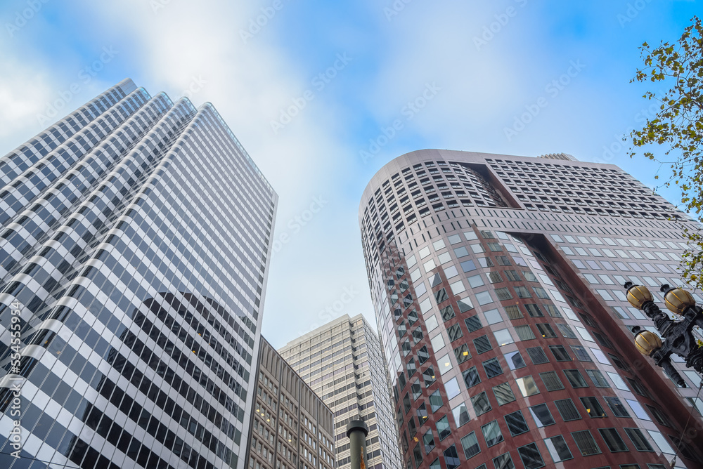 Low angle view of high rise office buildings against blue sky with clouds in autumn