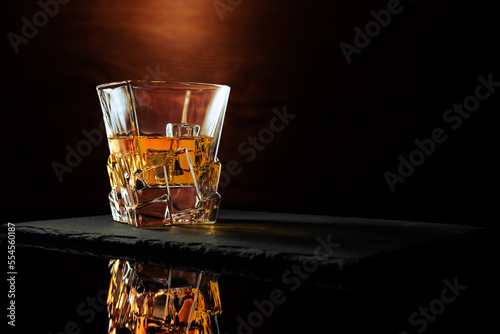 Whiskey Glass Reflection on stone and wood backdrop