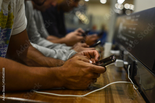 manos de hombres con teléfonos celulares conectados trabajando, en redes sociales o de ocio photo