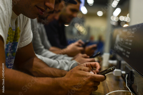 manos de hombres con teléfonos celulares conectados trabajando, en redes sociales o de ocio photo