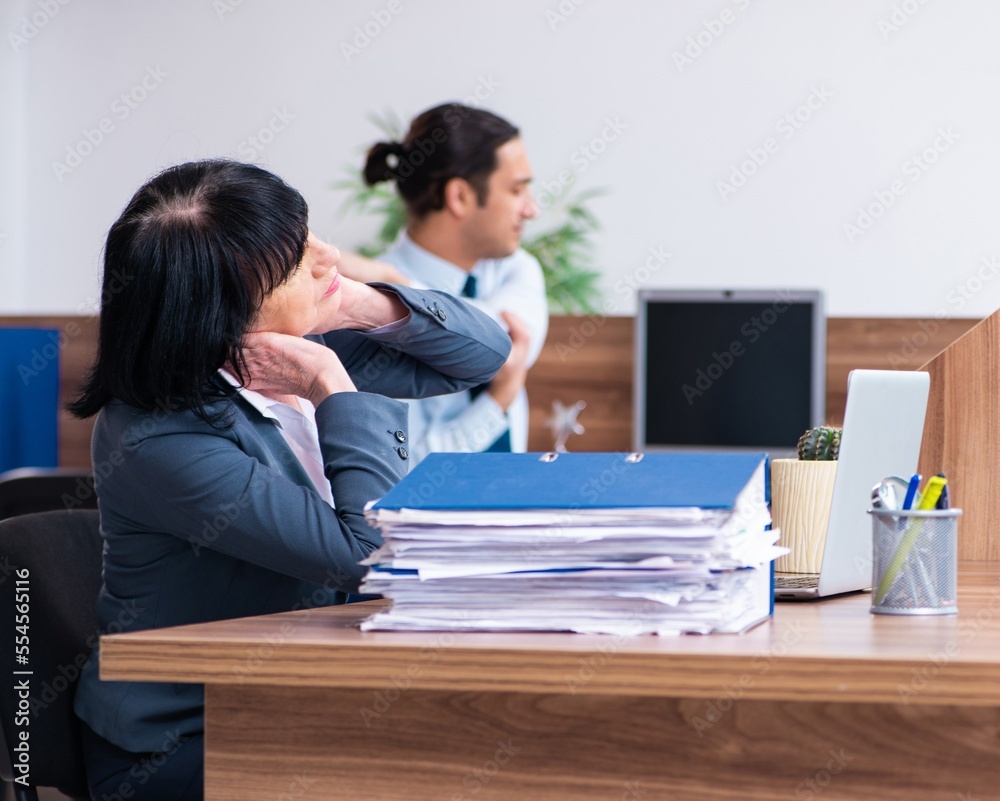 Two employees doing sport exercises in the office Two employees doing sport exercises in the office