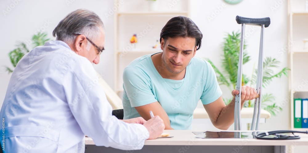 Obraz premium Young leg injured male patient visiting old doctor